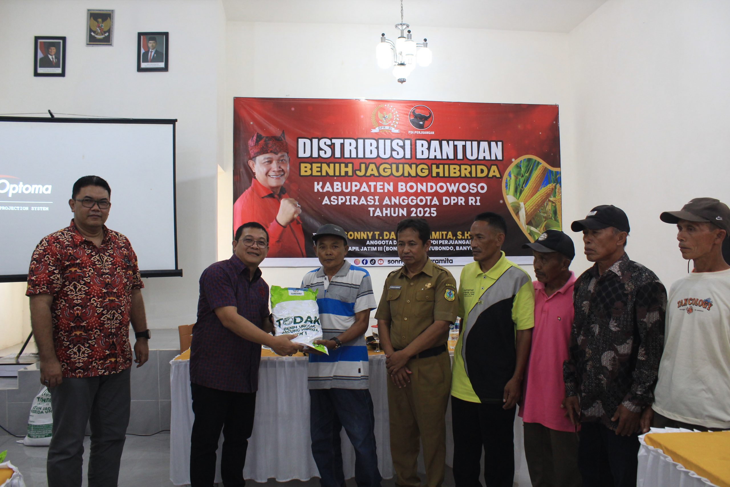 Sonny T. Danaparamita membagikan benih jagung kepada petani.